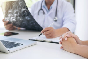 doctor reviewing diagnosis with patient holding scans