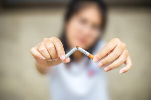 Woman breaking cigarette in half