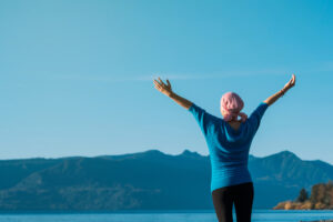 Woman with cancer overlooking a lake. 