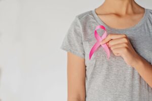 a lady holding a pink ribbon.